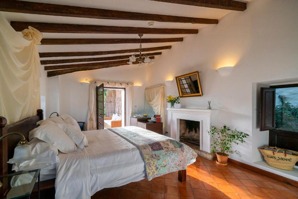 a bedroom with a large bed and a fireplace at Ca's Xorc Luxury Retreat - ADULTS ONLY in Sóller