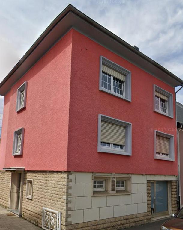 um edifício vermelho com janelas do lado em Acogedor apartamento em Dudelange