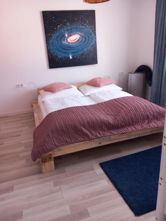 a bedroom with a bed with a painting of an universe at Ferienwohnungen Halbturn in Halbturn