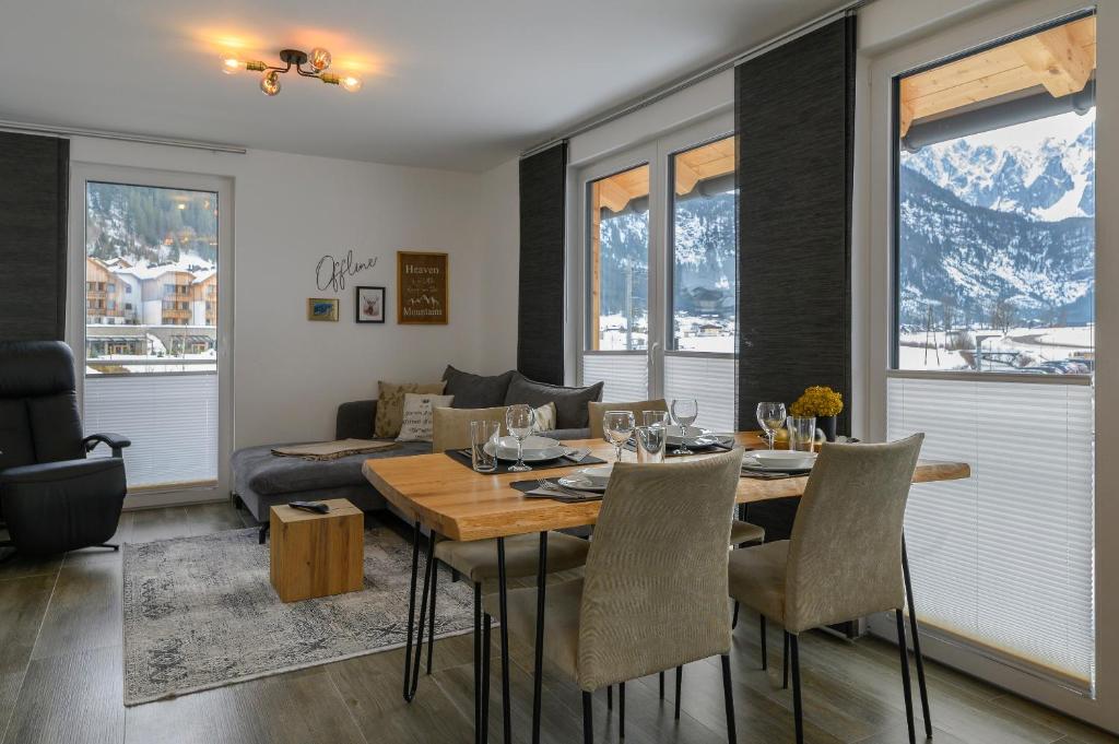 a dining room with a table and a couch at Ferienwohnung Klugis in Gosau