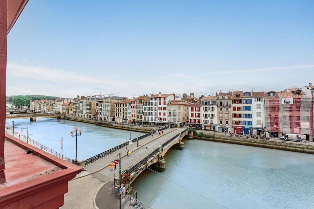 un pont sur une rivière dans une ville avec des bâtiments dans l'établissement Super T3 centre historique près halles, à Bayonne