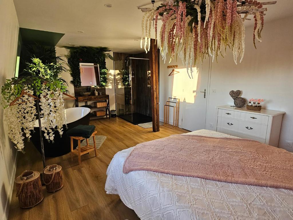 a bedroom with a bed and a bathroom with a tub at Appartement tout confort à proximité de Lille, Lens et Arras in La Bassée