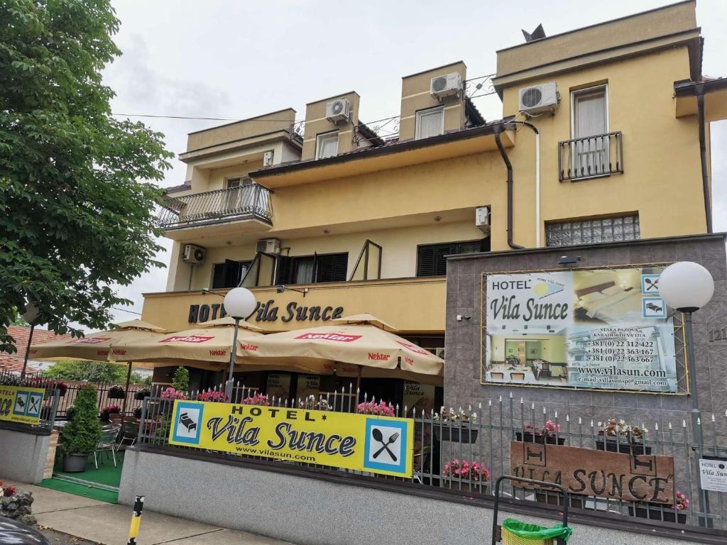 un edificio con sombrillas frente a un restaurante en Hotel Vila Sunce, en Stara Pazova