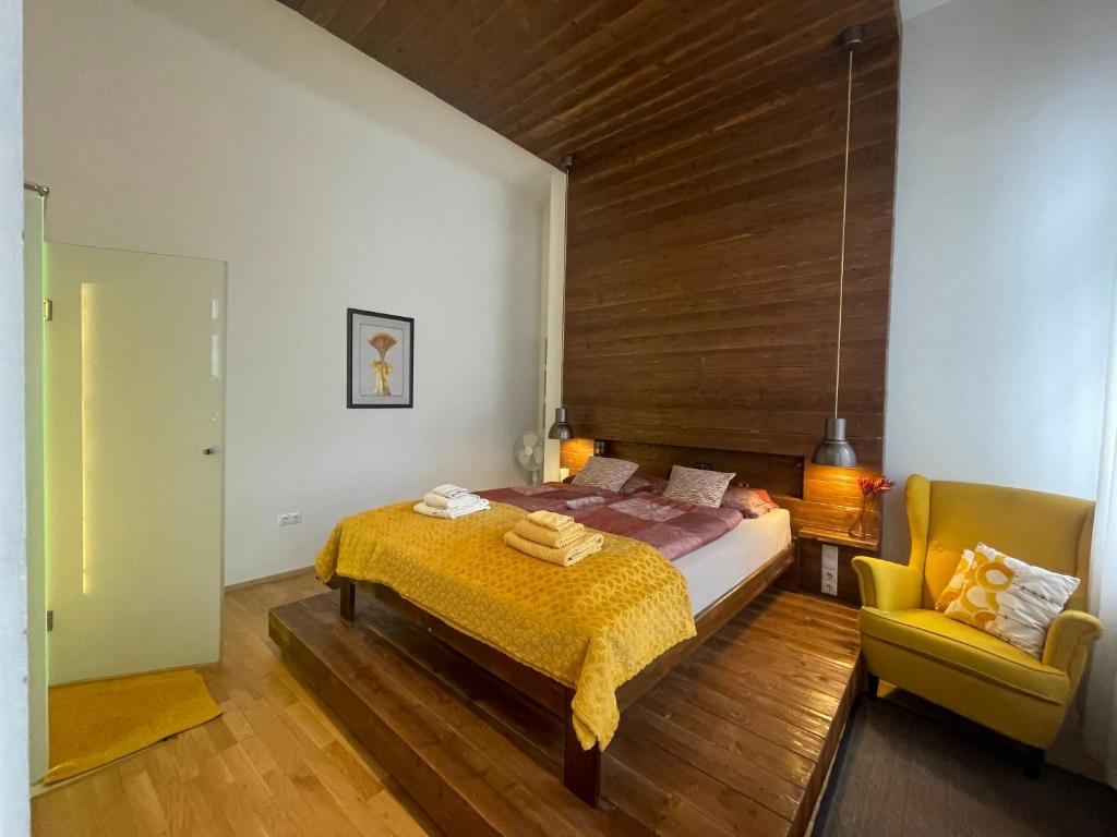 a bedroom with a bed and a chair in it at Amber Pearl Apartment 2 rooms and 2 bathrooms at Kálvin Square in Budapest
