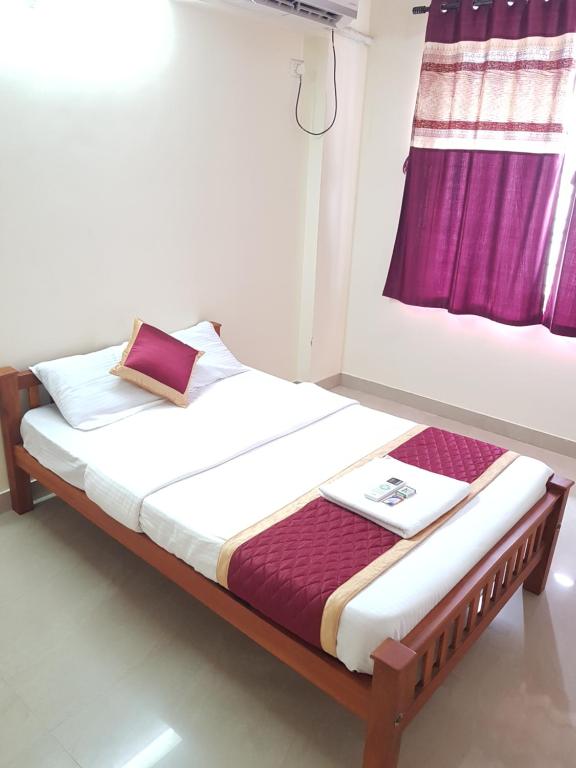 uma cama num quarto com uma janela em MSK Gardenia Service Apartments em Cochin