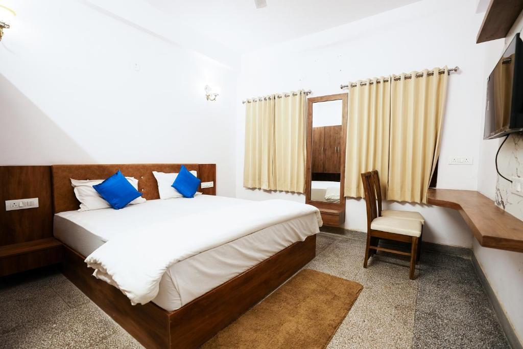 um quarto com uma cama, uma secretária e uma cadeira em Devdarshan Hotel & Restaurant em Udaipur