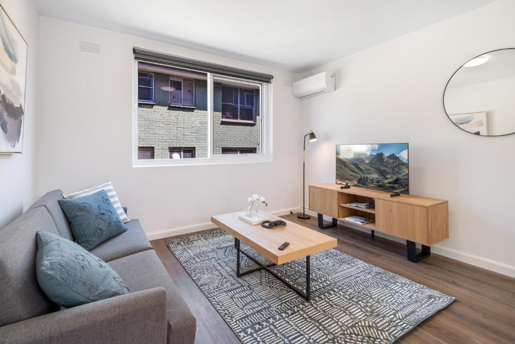 un soggiorno con divano e tavolo di 1-Bed in Vibrant St Kilda Perfect for a Staycation a Melbourne