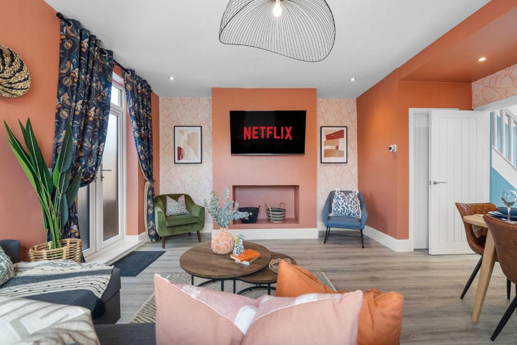uma sala de estar com paredes cor de laranja e uma lareira em 4-BR Chic Spacious House with Parking, Central Bolton, Links to Manchester, Sleeps - 11 by Blue Puffin Stays em Farnworth