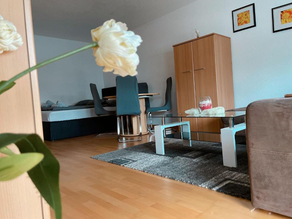 una sala de estar con una mesa y una flor blanca en ZV-Scholtz Burghausen, Haydnstr.11 AP-3, en Burghausen