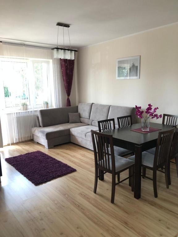 a living room with a couch and a table and chairs at Apartament Klaudia in Stegna