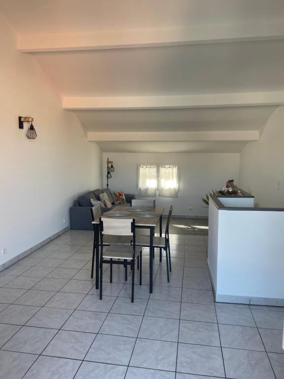 a room with a table and chairs and a couch at Appartement des Ponts Bleus in Martigues