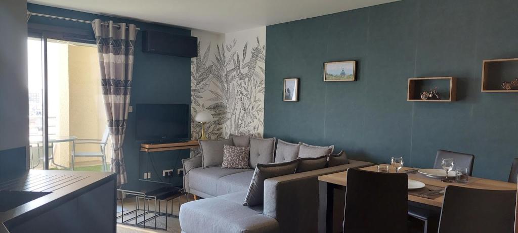una sala de estar con un sofá y una mesa en LE PANORAMIQUE, en Toulouse