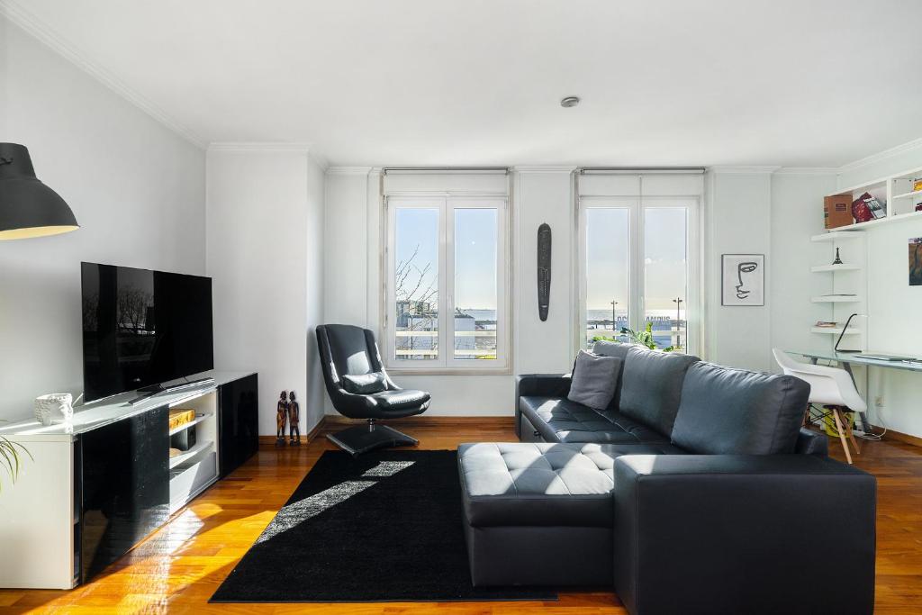 Una sala de estar con un sofá y un televisor. en Lisbon Riverview Apartment by Premium Lisbon Stays, en Lisboa