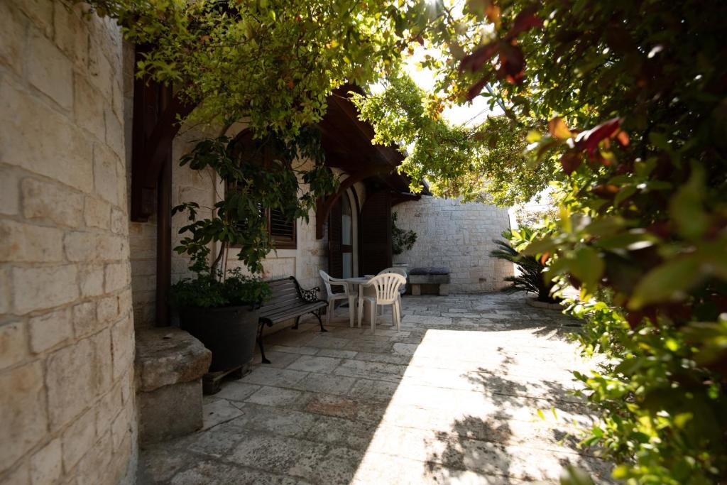 a patio with a bench and a table and chairs at I Trulli Di Badi in Locorotondo