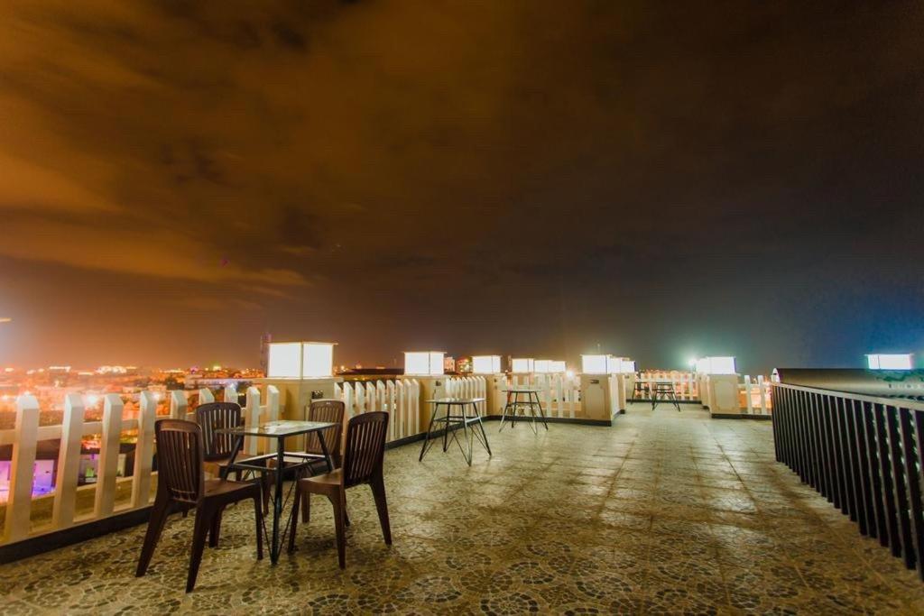 um quarto com mesas e cadeiras numa varanda à noite em Hotel Hoàng My Phú Yên em Liên Trì (3)