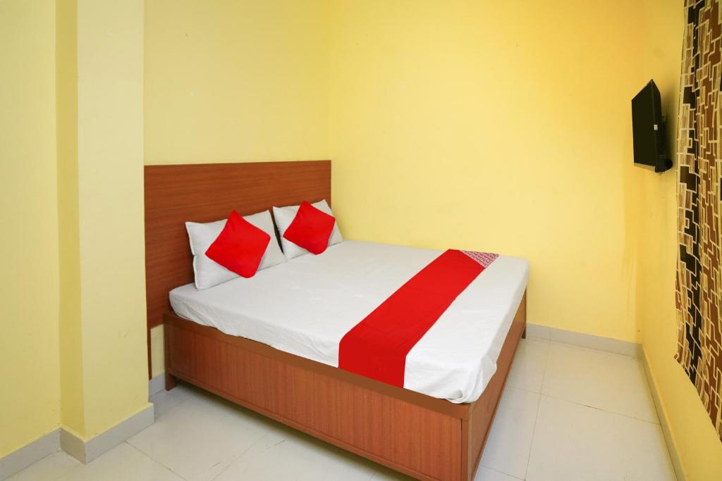 - une chambre avec un lit et 2 oreillers rouges dans l'établissement OYO Flagship Hotel Sai Saugat, à Bilāspur