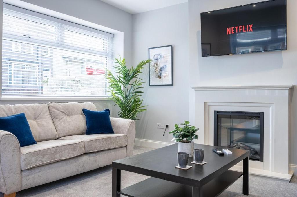 a living room with a couch and a fireplace at Brynglas House by Tŷ SA in Newport