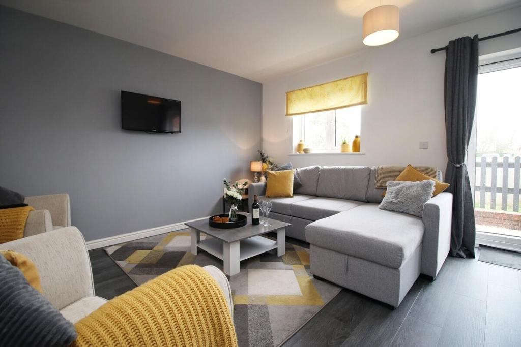 uma sala de estar com um sofá e uma mesa em Buxton Way by Tŷ SA - 3 bedroom house em Royal Wootton Bassett
