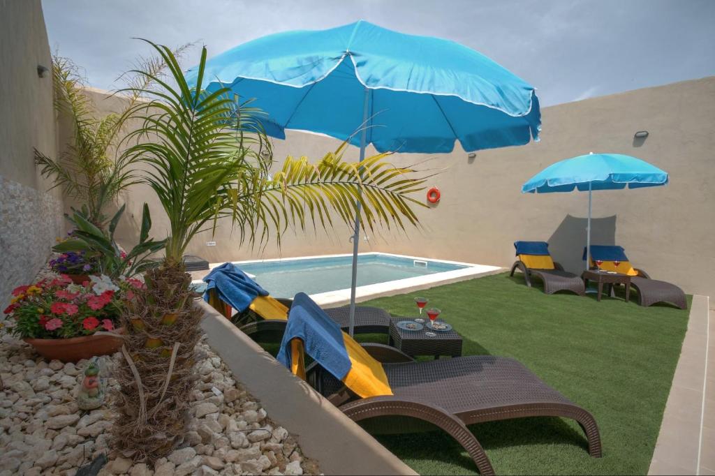 - une piscine avec des chaises longues et des parasols dans l'établissement Villa Sunview, à Rabat