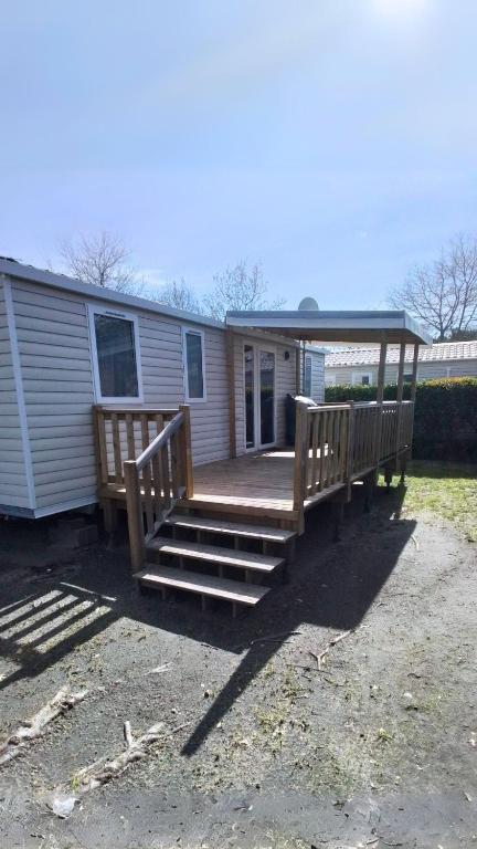 une maison avec une terrasse couverte et des escaliers menant à une maison dans l'établissement CAMPING SIBLU - LA RESERVE **** - Mobile Home - 3 ch. - (8pers), à Gastes
