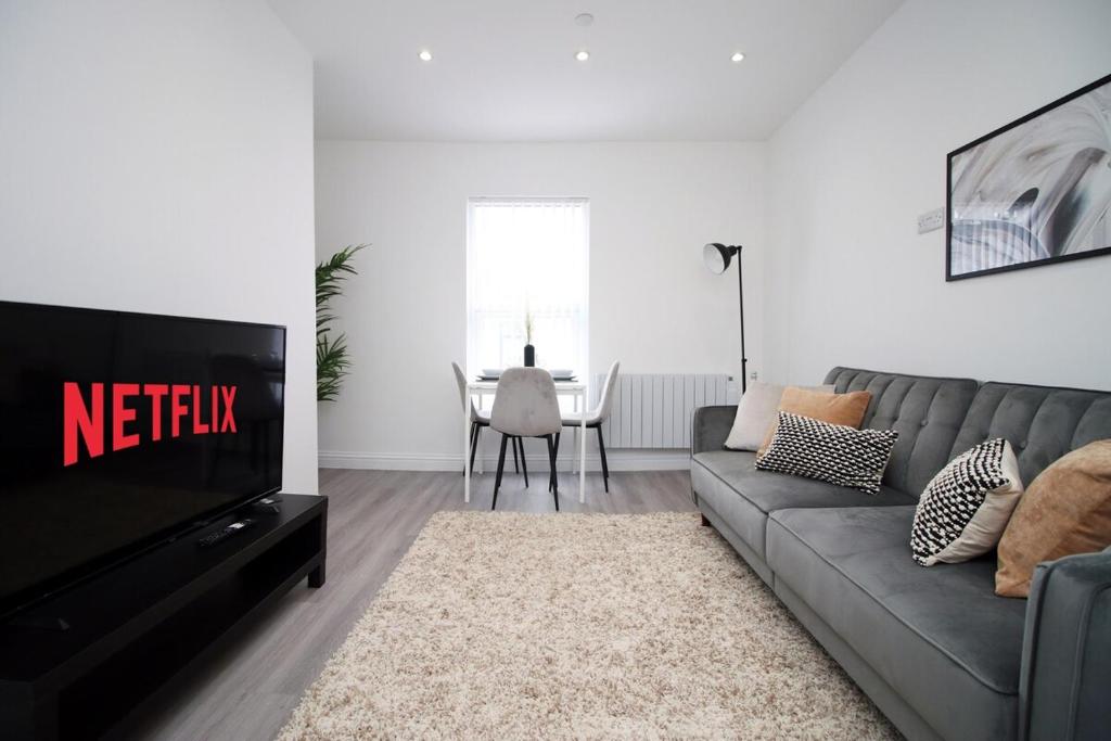 Modern 1 Bedroom - Caxton Place by Tŷ SA في نيوبورت: غرفة معيشة مع أريكة وتلفزيون