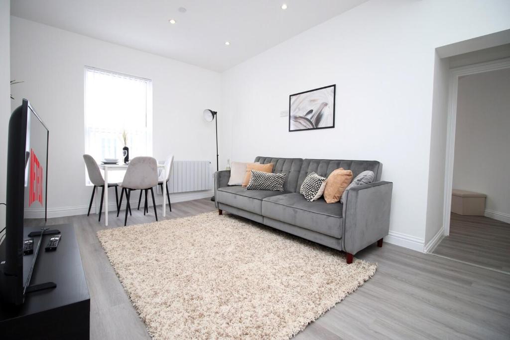 a living room with a couch and a table at Modern 1 Bedroom - Caxton Place by Tŷ SA in Newport