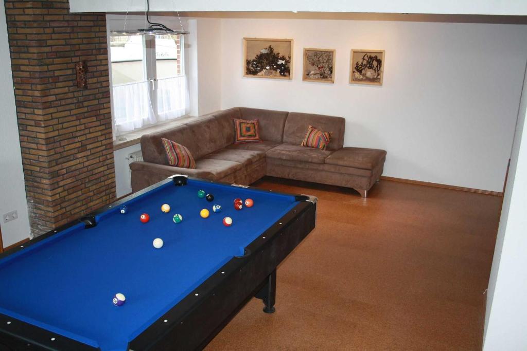 a living room with a pool table and a couch at Ferienhaus Seestern in Schwackendorf