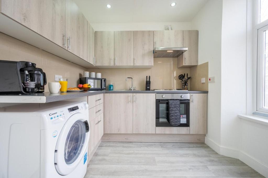 a kitchen with a washer and a washing machine at Modern 1 bedroom - Church View 4 by Tŷ SA in Newport