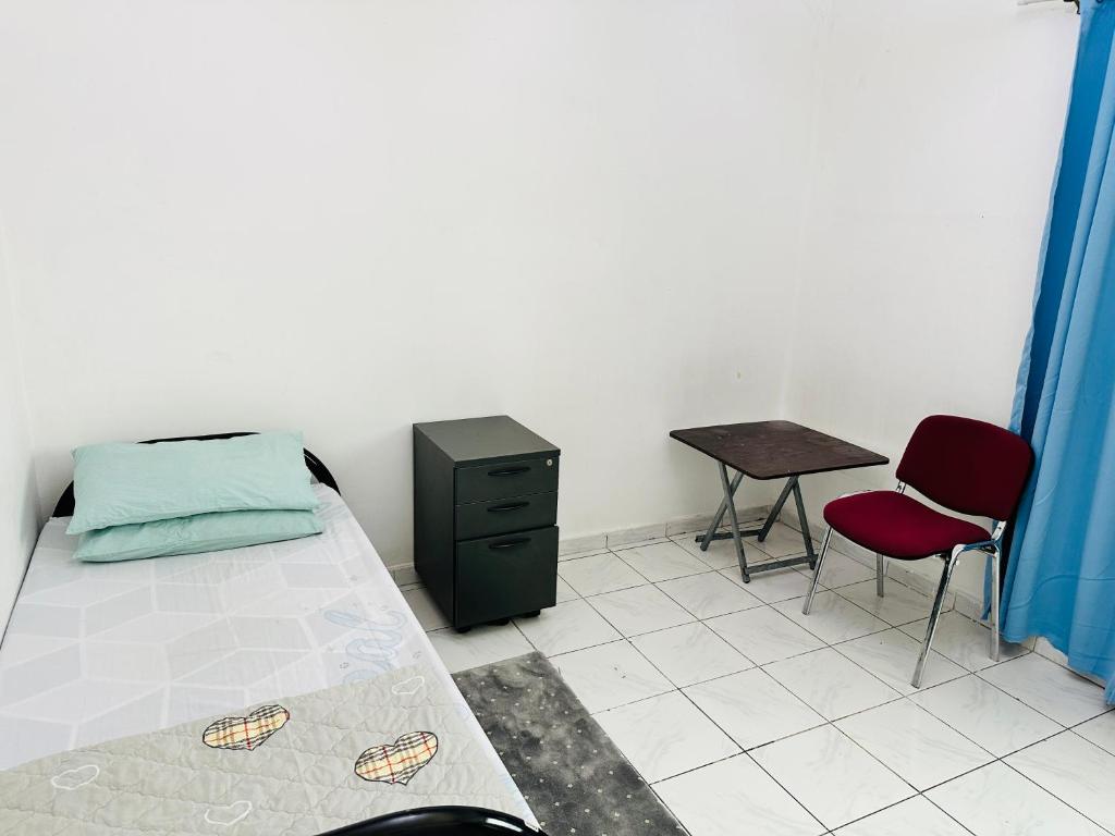 シャルジャにあるBoys accommodationのベッドルーム1室(ベッド1台、テーブル、椅子付)