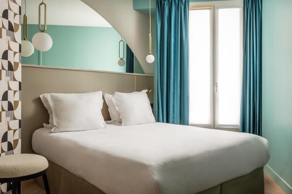 パリにあるアルク エリーゼのベッドルーム(青いカーテン付きの白い大型ベッド1台付)
