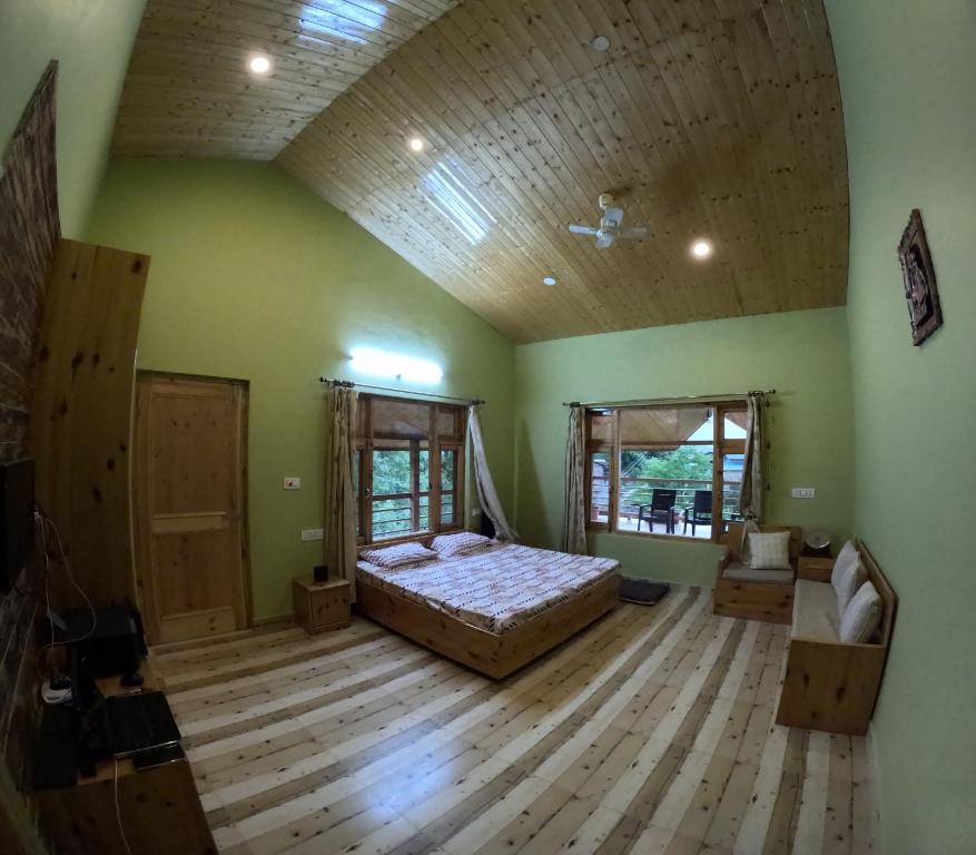 1 dormitorio grande con 1 cama y suelo de madera en The Naggar Trails, en Nagar