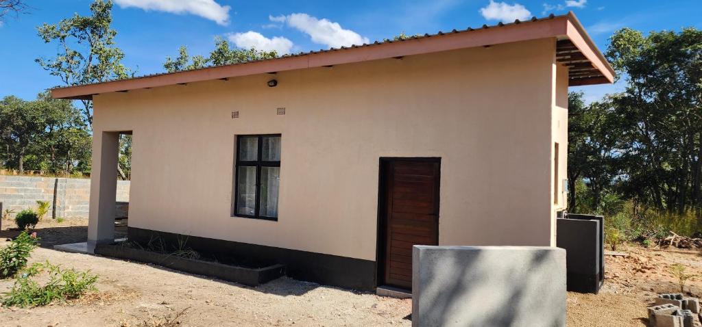 ein kleines Haus mit einer Tür im Hof in der Unterkunft Aima Villas in Chanamo