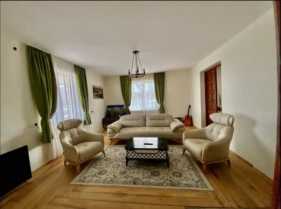 a living room with a couch and chairs and a table at Gudauri Deka House in Gudauri