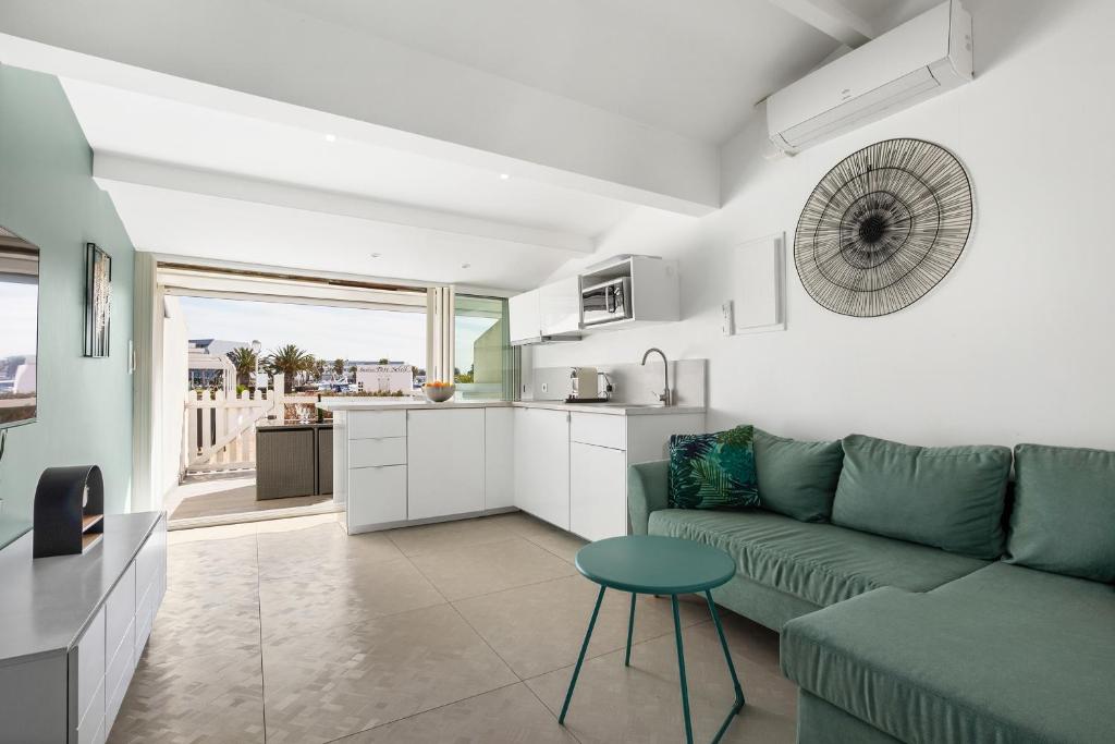 un salon avec un canapé vert et une cuisine dans l'établissement Sun Marina Port soleil, au Cap d'Agde