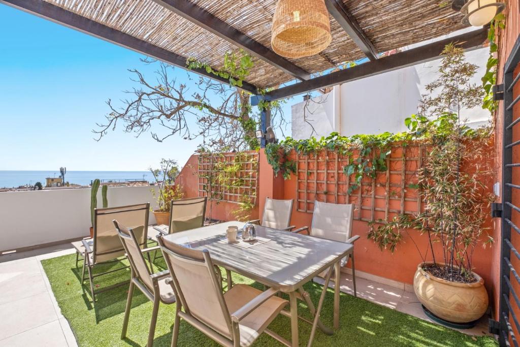 a patio with a table and chairs and a fence at Mar de fondo en Pedregalejo in Málaga