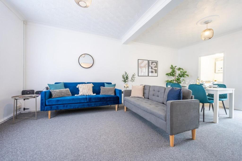 a living room with a blue couch and a table at Clayton Street by Tŷ SA in Newport