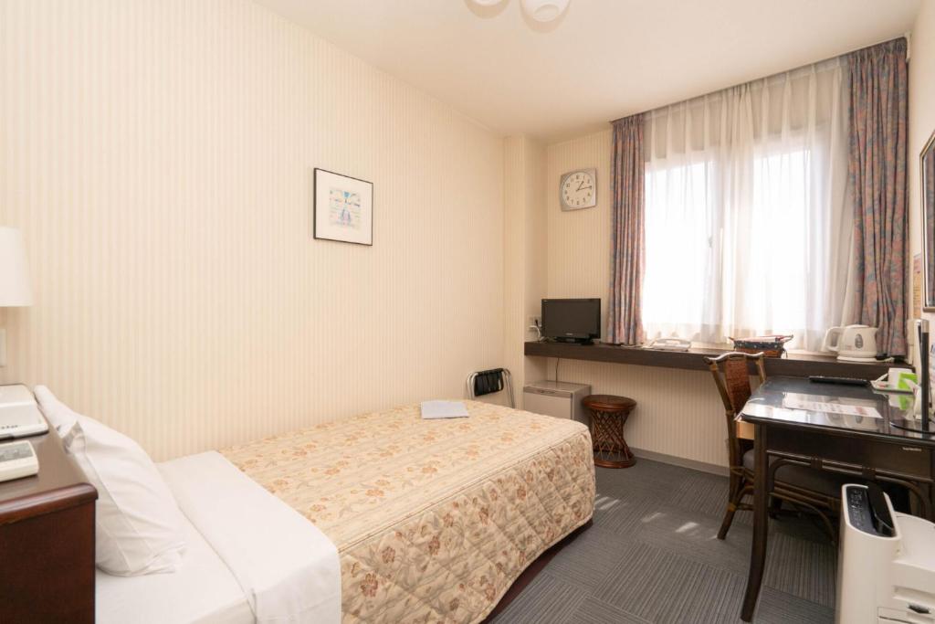 Postel nebo postele na pokoji v ubytování Kiryu Ace Hotel