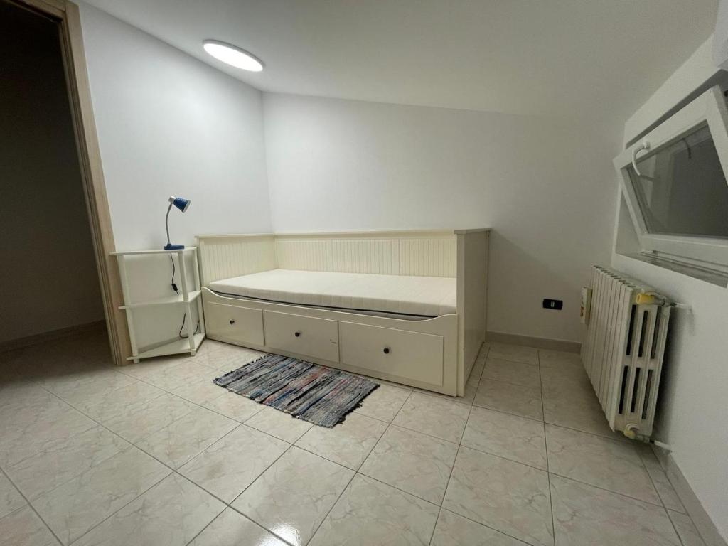 Dieses weiße Zimmer verfügt über ein Bett und einen Kühlschrank. in der Unterkunft Mansarda a Foiano in Foiano di Val Fortore