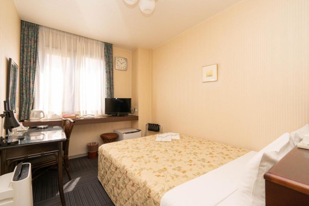 Postel nebo postele na pokoji v ubytování Kiryu Ace Hotel