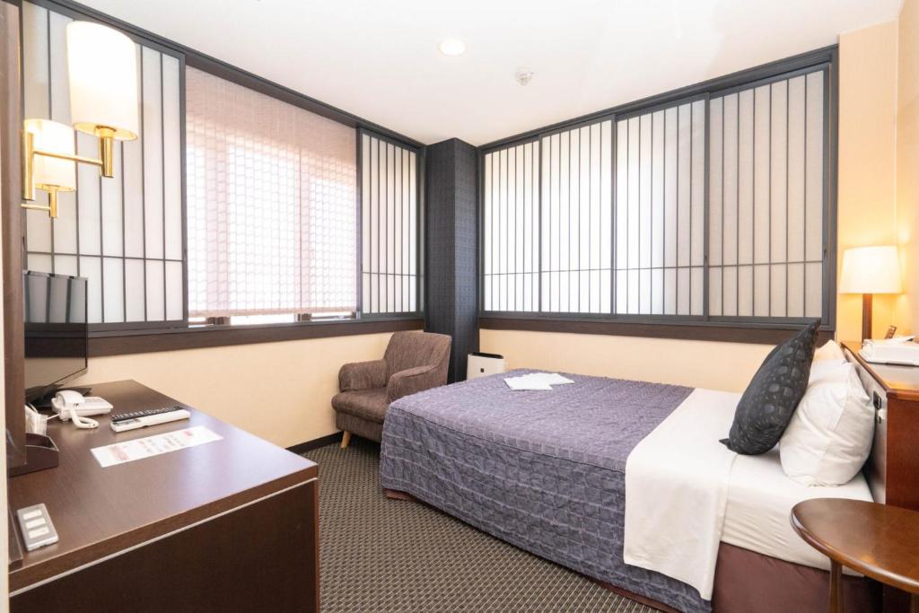Postel nebo postele na pokoji v ubytování Kiryu Ace Hotel