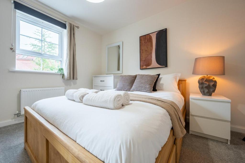 um quarto com uma cama grande e lençóis brancos em Close to Warwick University - Clover Way by Tŷ SA em Canley