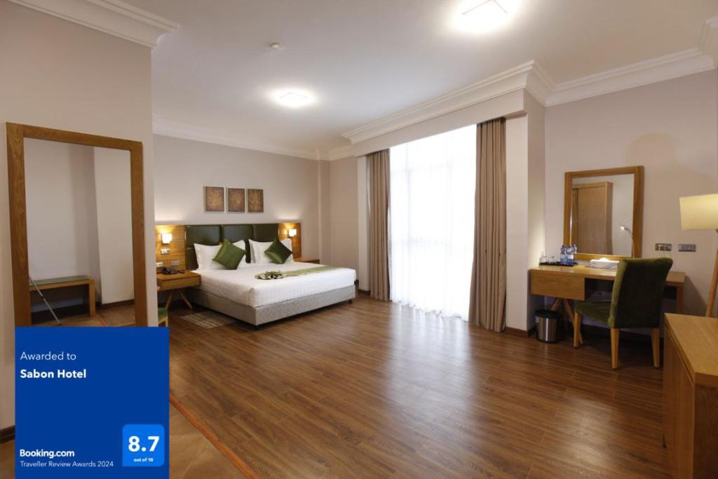 1 dormitorio con 1 cama y escritorio en una habitación en Sabon Hotel, en Addis Ababa