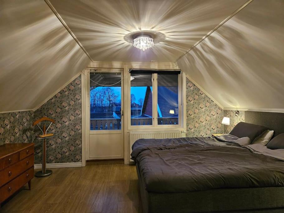 um quarto com uma cama e duas janelas em Gästhuset Sätuna em Sätuna