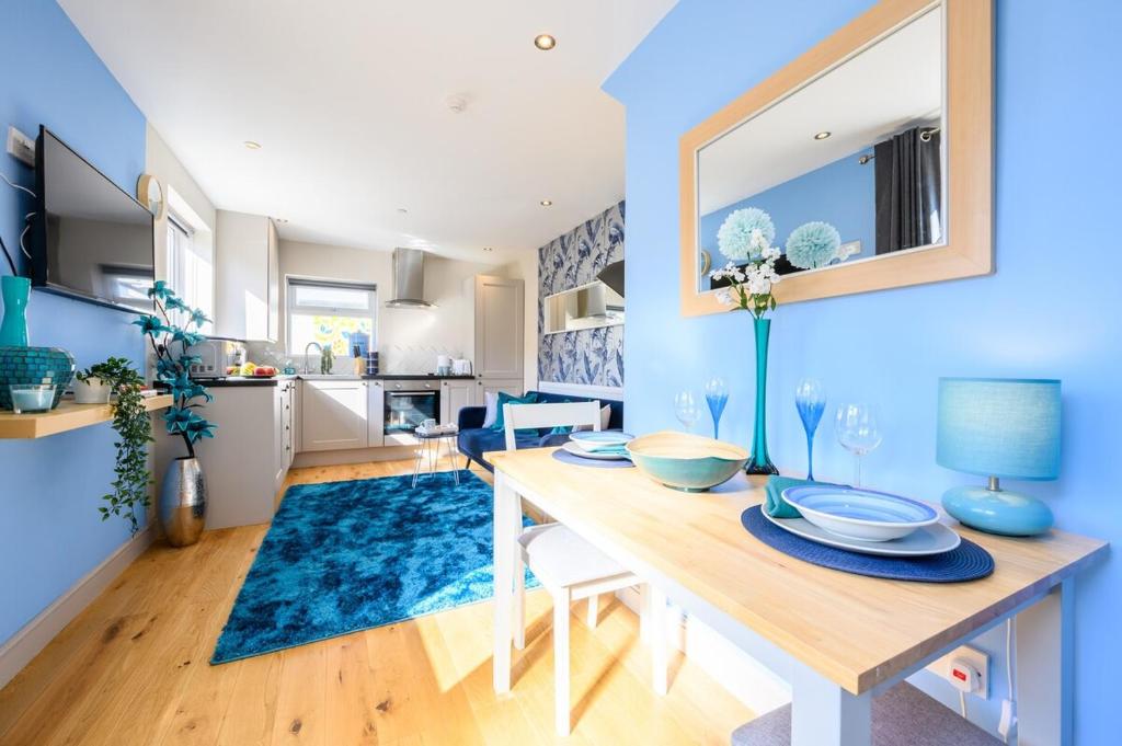 uma sala de jantar com uma mesa e uma parede azul em Central Location - Riverside Gardens #3 by Tŷ SA em Cardiff