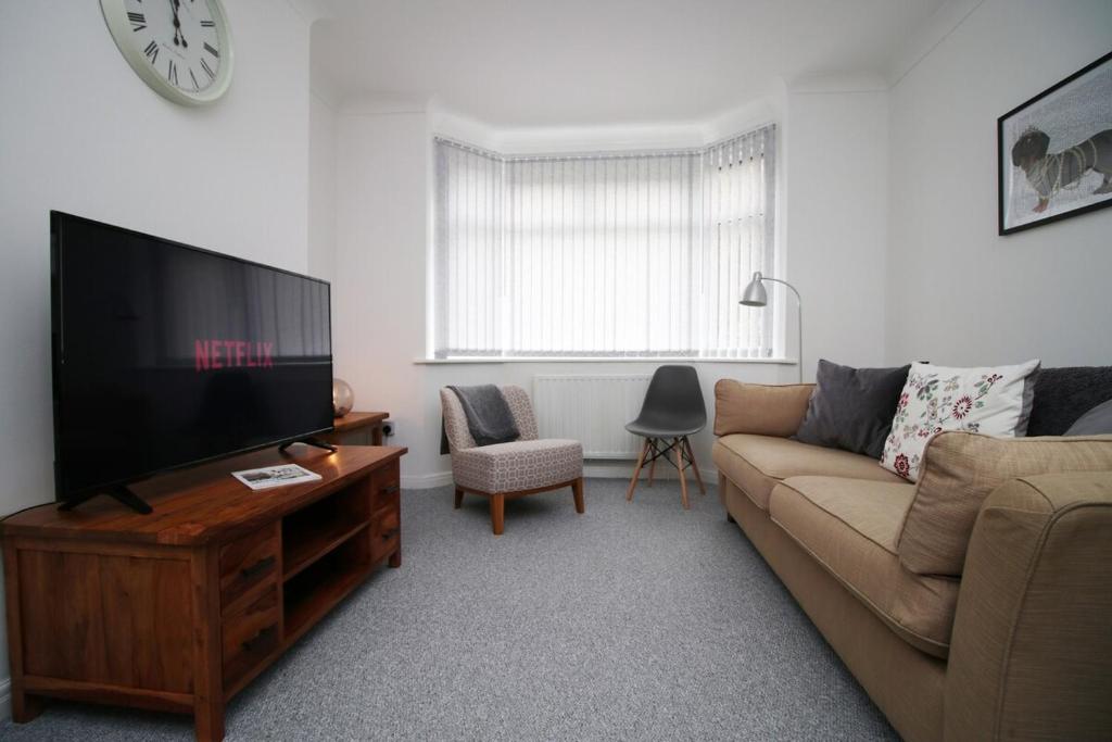 salon z kanapą i telewizorem z płaskim ekranem w obiekcie Parkview by Tŷ SA - spacious 3 bed in Newport w mieście Newport