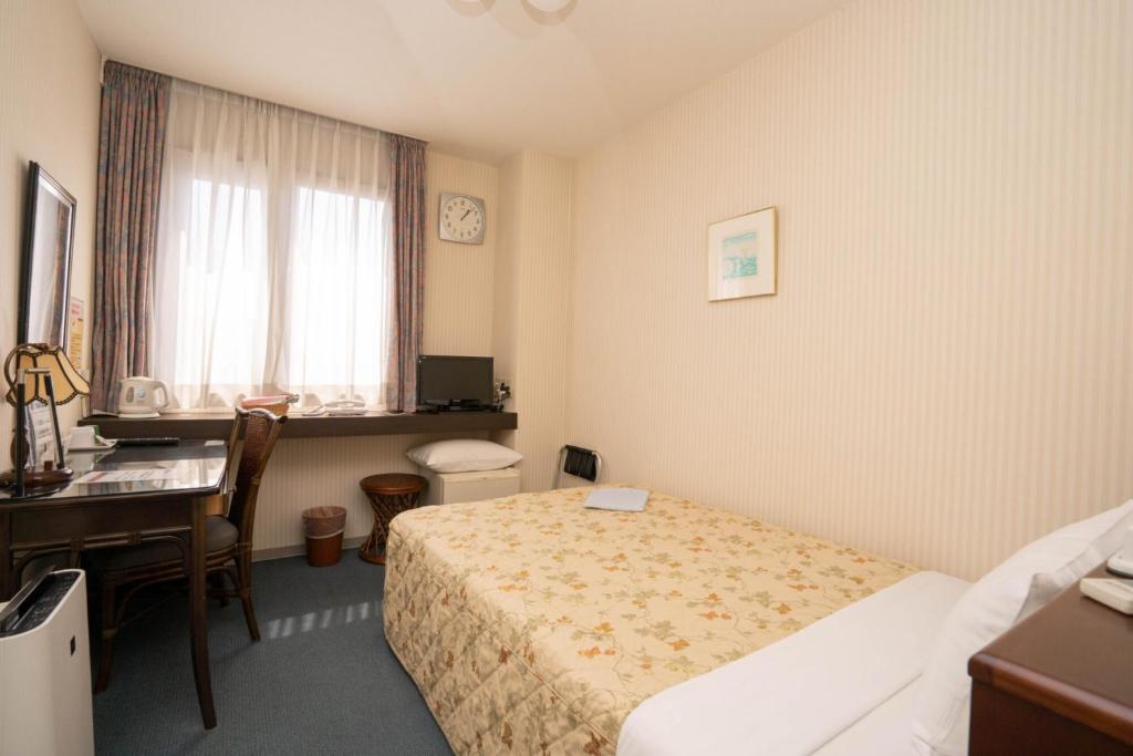 Postel nebo postele na pokoji v ubytování Kiryu Ace Hotel