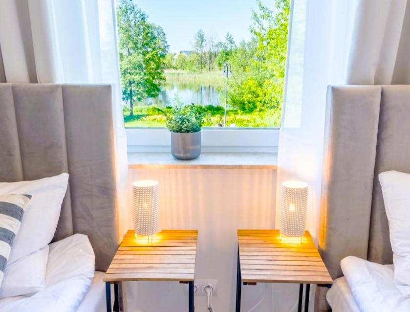 two tables with lamps in front of a window at Unique View Apartment in Iława