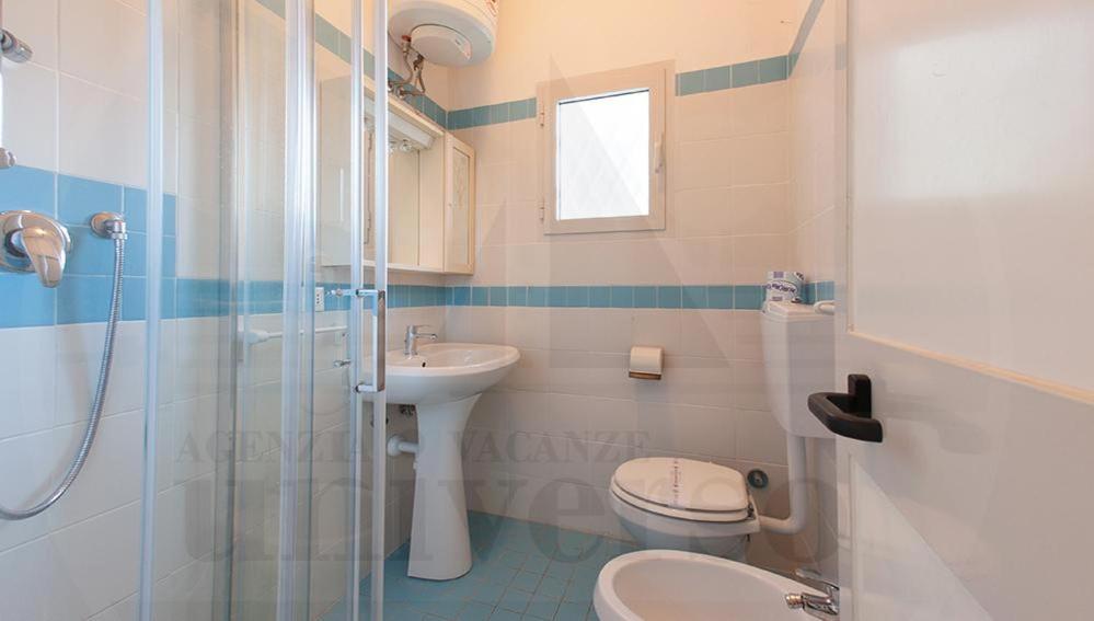 La salle de bains est pourvue d'un lavabo, de toilettes et d'une douche. dans l'établissement Bungalow Dancalia, à Eraclea Mare