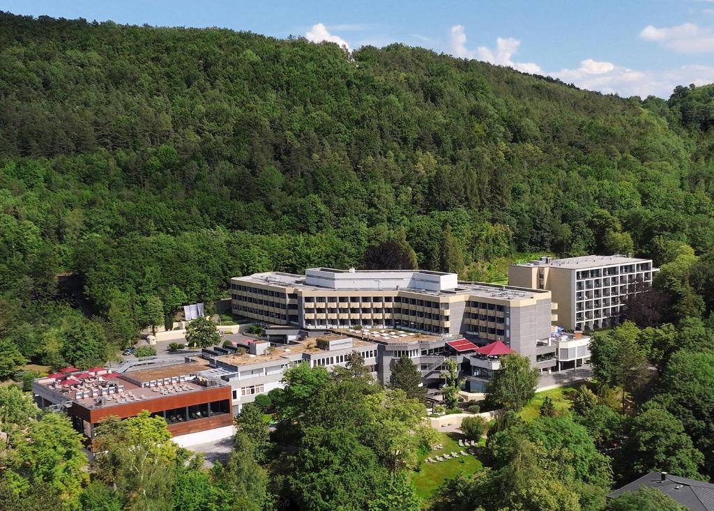 an aerial view of a building in front of a mountain at Parkhotel CUP VITALIS in Bad Kissingen