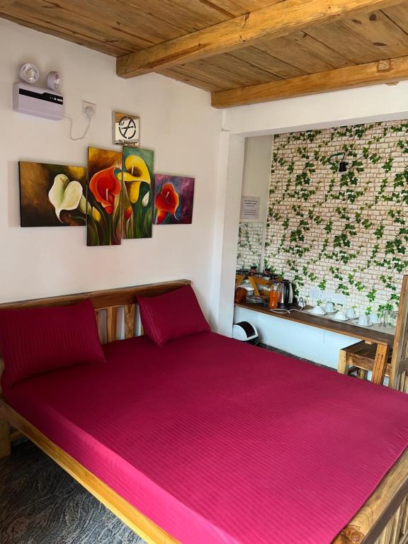 a bedroom with a large bed with pink sheets at Twilight Villas in Rattota